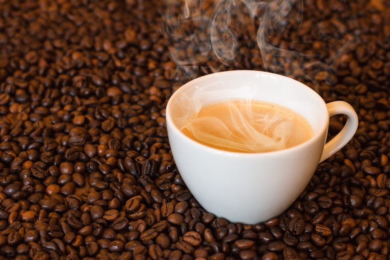 Tasse Kaffee auf einen Bett von Kaffeebohnen
